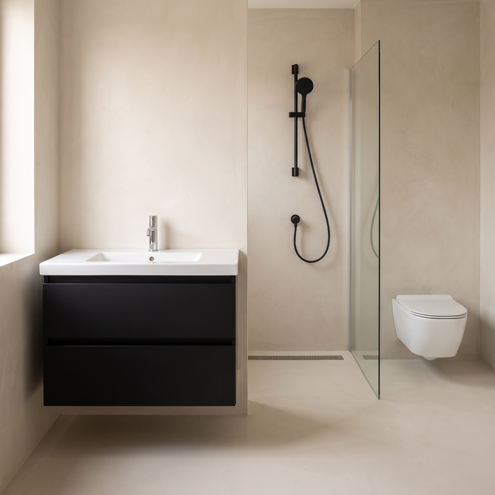 Badkamer met een mat zwart badmeubel met een witte wastafel, een mat zwarte glijstangset met handdouche, een douchegoot in de vloer en een wit wandcloset